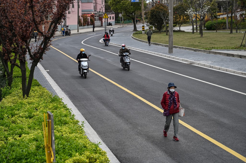 Homem caminha em rua de Xangai, na China