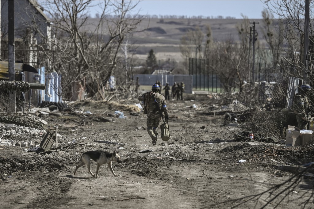 Um militar ucraniano caminha na vila de Mala Rogan, a leste de Kharkiv, depois que as tropas ucranianas retomaram a vila em 28 de março de 2022