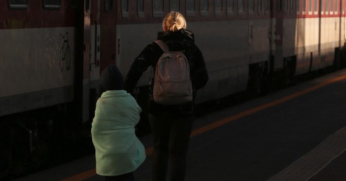 Refugiada ucraniana esperando o trem com o filho