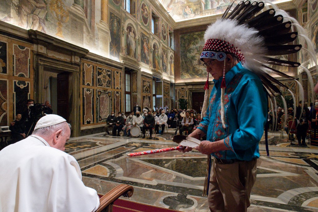 Papa Francisco recebendo um presente do chefe de uma delegação durante uma audiência às delegações indígenas do Canadá no Vaticano