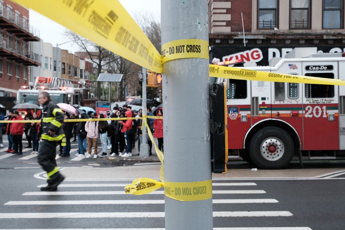 Polícia e equipes de emergência se reúnem no local de um tiroteio de várias pessoas fora da estação de metrô 36 St em 12 de abril de 2022 no bairro do Brooklyn, em Nova York. 