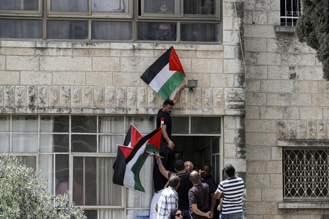 Pessoas se reúnem com bandeiras palestinas do lado de fora da casa da família da jornalista da Al Jazeera, Shireen Abu Aqleh, no bairro palestino de Beit Hanina, em Jerusalém Oriental, anexada a Israel, em 11 de maio de 2022.