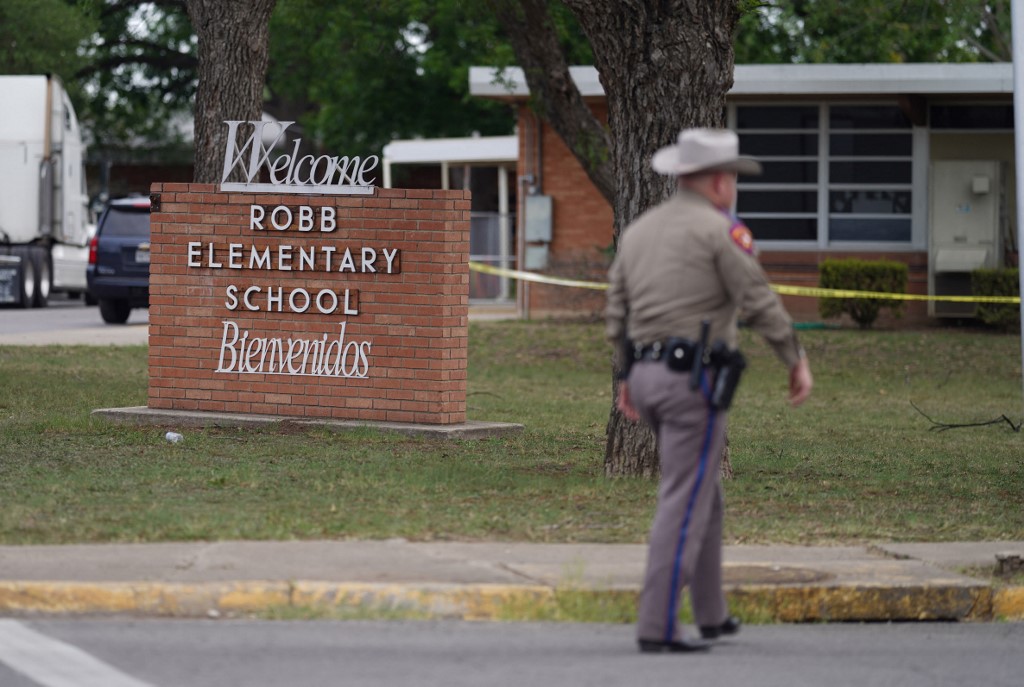 Um oficial sai da Robb Elementary School em Uvalde, Texas, em 24 de maio de 2022. Um atirador de 18 anos matou 14 crianças e um professor em uma escola primária no Texas na terça-feira, de acordo com o governador do estado. tiroteio em escola mais mortal 