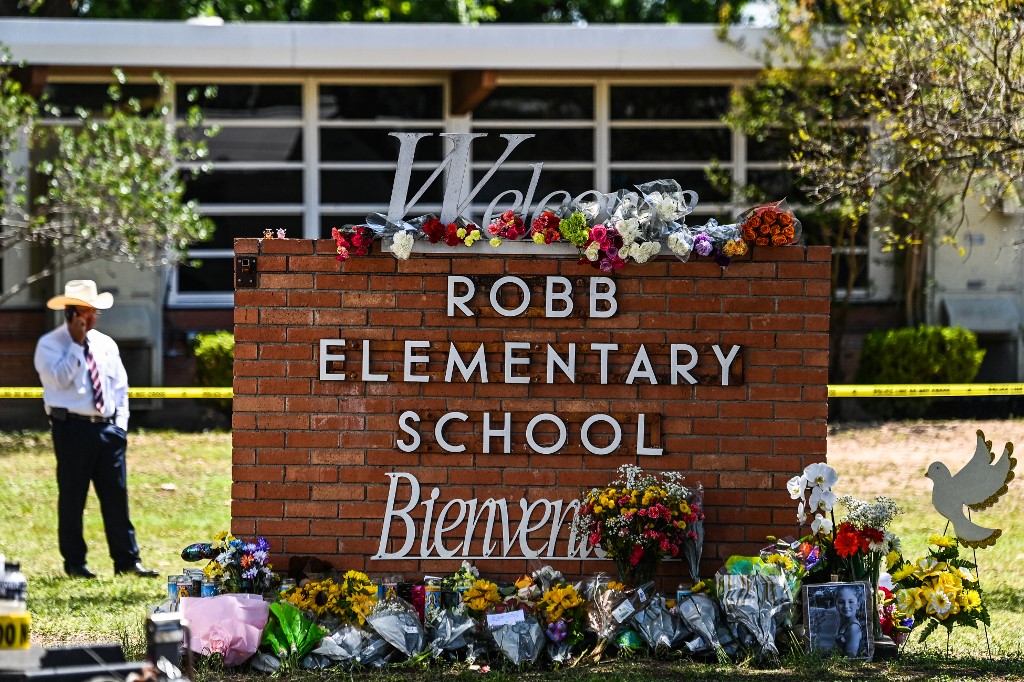 Flores são colocadas em um memorial improvisado em frente à Robb Elementary School , Texas