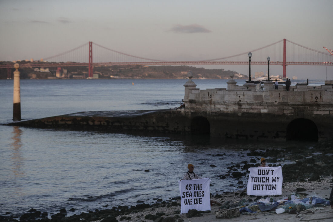 Ativistas ambientais, em Portugal, com placas com os dizeres 