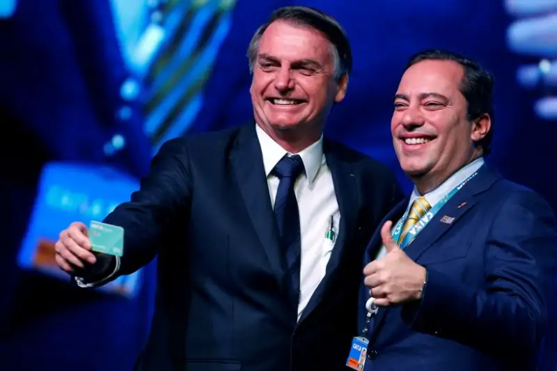 Presidente Jair Bolsonaro, junto ao então presidente da Caixa, Pedro Guimarães, que pediu demissão nesta quarta-feira (29)