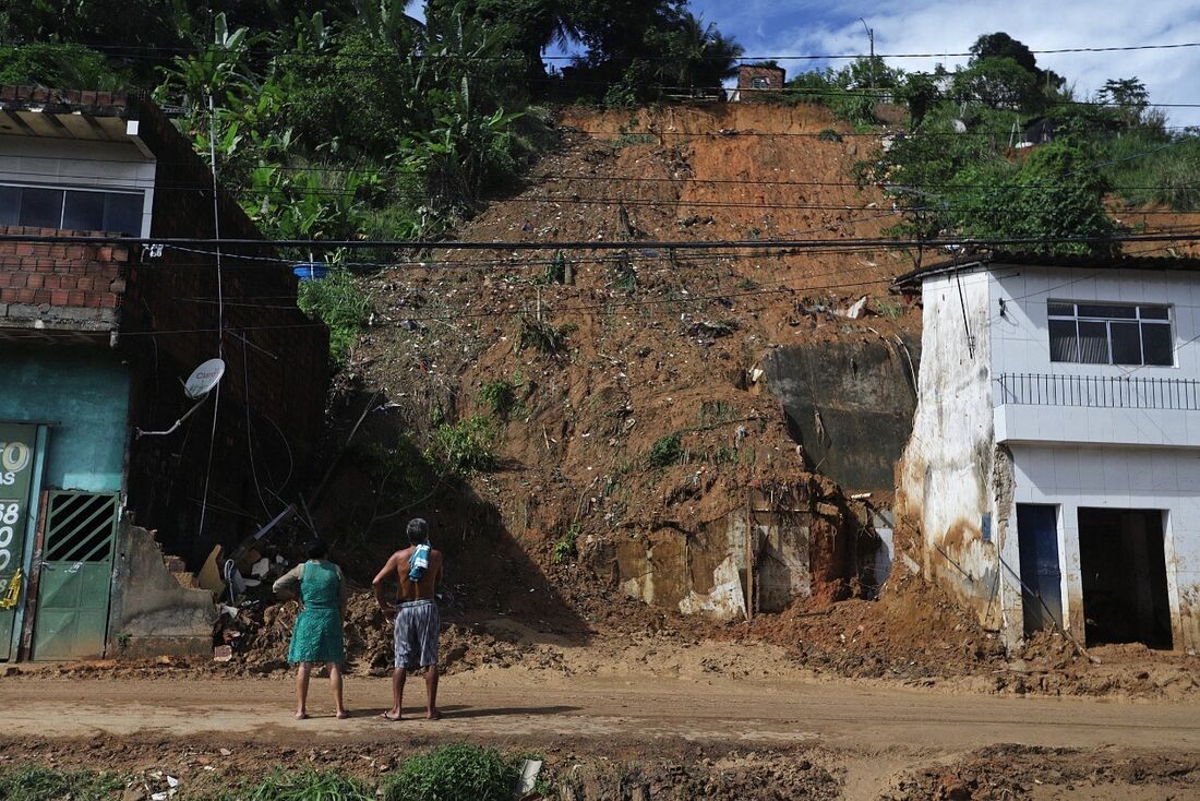 Casal observa barreira que caiu por cima de casas em Pernambuco