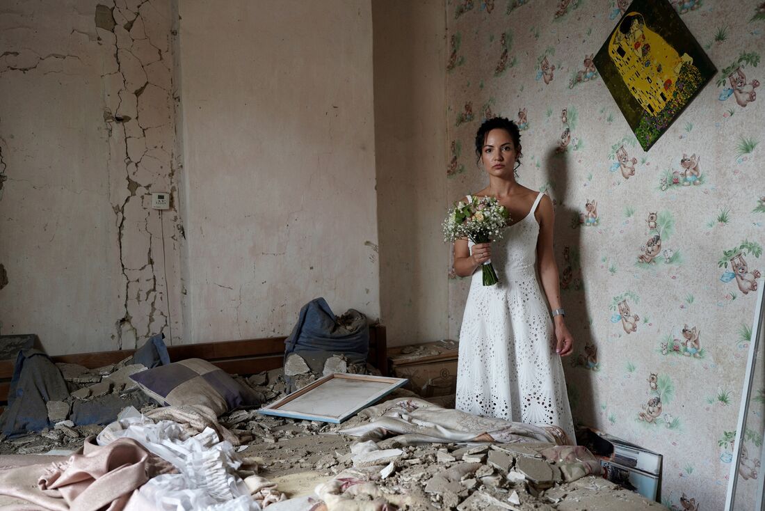 Noiva posa para foto usando seu vestido de casamento na sua residência bombardeada pelas tropas russas no dia 16 de julho