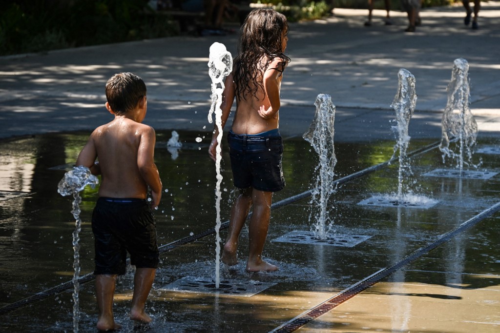 Crianças se refrescam em fontes de água no centro de Nîmes, no sul da França, quando uma onda de calor atinge a França em 1&ordm; de agosto de 2022