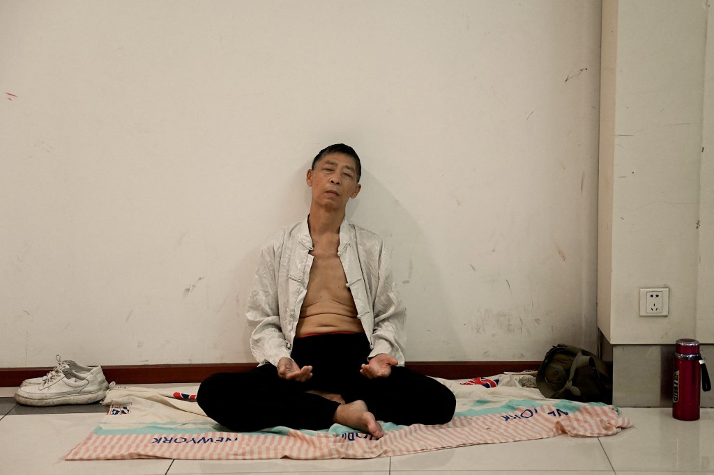 Um homem descansa em uma estação de metrô para se refrescar e evitar temperaturas escaldantes ao ar livre na cidade de Chongqing, no sudoeste da China, em 24 de agosto de 2022