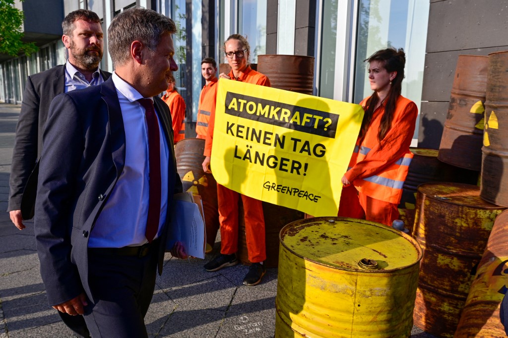 Ativistas do Greenpeace fazem uma manifestação enquanto o ministro alemão da Economia e Proteção Climática, Robert Habeck, chega para dar uma entrevista coletiva sobre as condições das usinas nucleares 