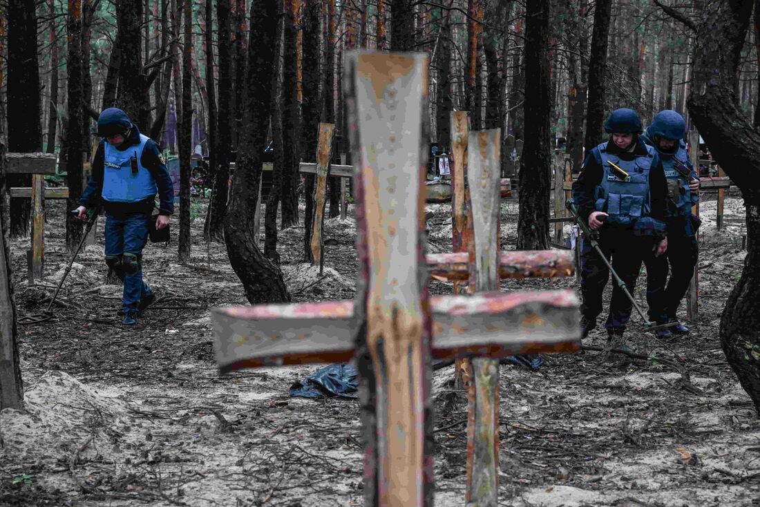 Centenas de sepulturas marcadas com uma cruz em uma floresta nas proximidades de Izium