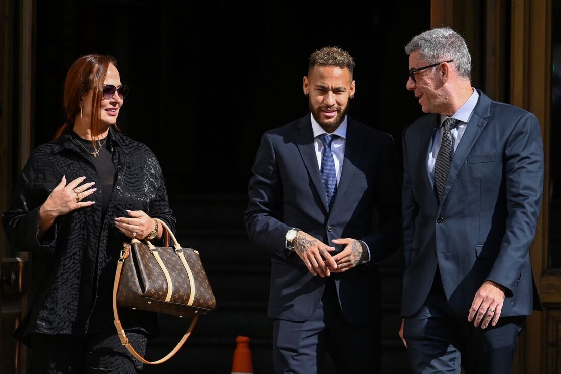 Nesta foto de arquivo tirada em 18 de outubro de 2022, o atacante brasileiro do Paris Saint-Germain Neymar (C) sai com sua mãe Nadine Gonçalves da Silva Santos (E) após participar de uma audiência no tribunal de Barcelona no segundo dia de seu julgamento