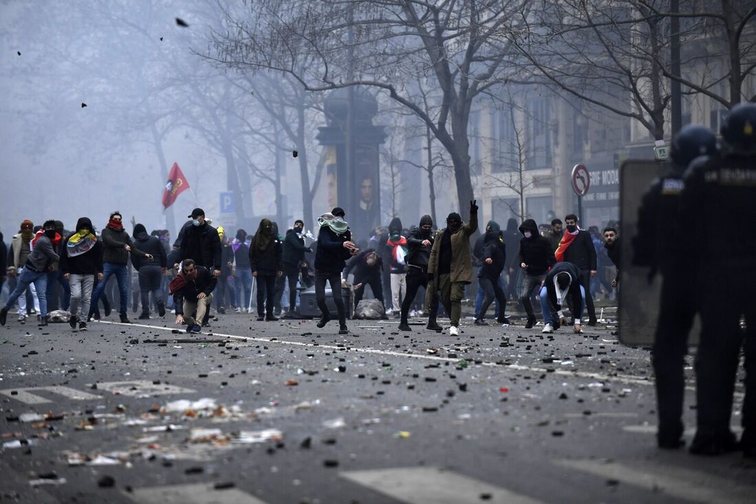 Manifestantes atiram pedras durante confrontos após uma manifestação de membros da comunidade curda, um dia depois que um atirador abriu fogo em um centro cultural curdo matando três pessoas, na Place de la Republique, em Paris, em 24 de dezembro de 2022