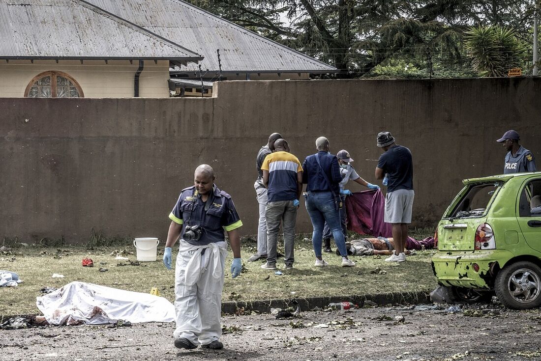 Oficiais do Serviço de Polícia da África do Sul (SAPS) e especialistas forenses ao lado de corpos em Boksburg, em 24 de dezembro de 2022. Nove pessoas morreram e outras 40 ficaram feridas na explosão de um caminhão-tanque