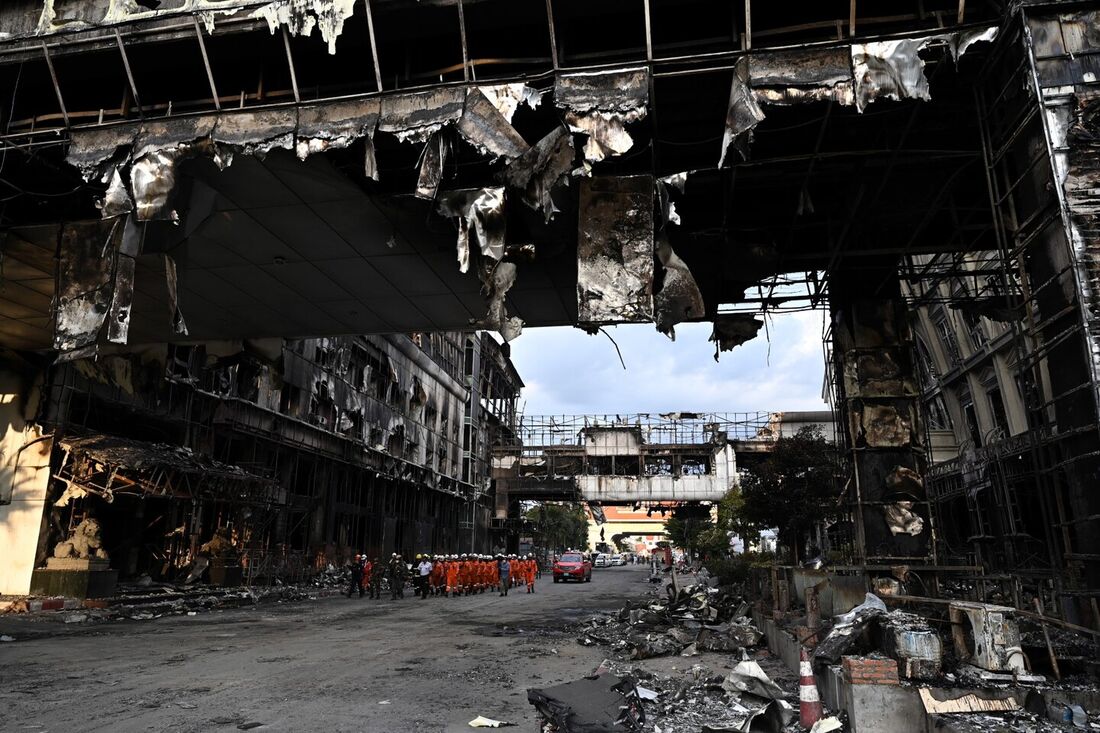 Uma equipe de resgate caminha por uma parte queimada do hotel-cassino Grand Diamond City após um grande incêndio no complexo