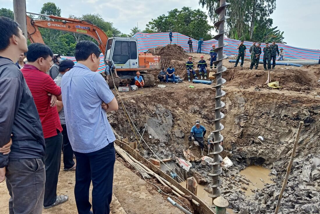 Equipes de resgate olham para o local onde um menino de 10 anos estava preso em um poço de 35 metros de profundidade em uma área de construção de ponte na província de Dong Thap, no Vietnã, em 2 de janeiro de 2023