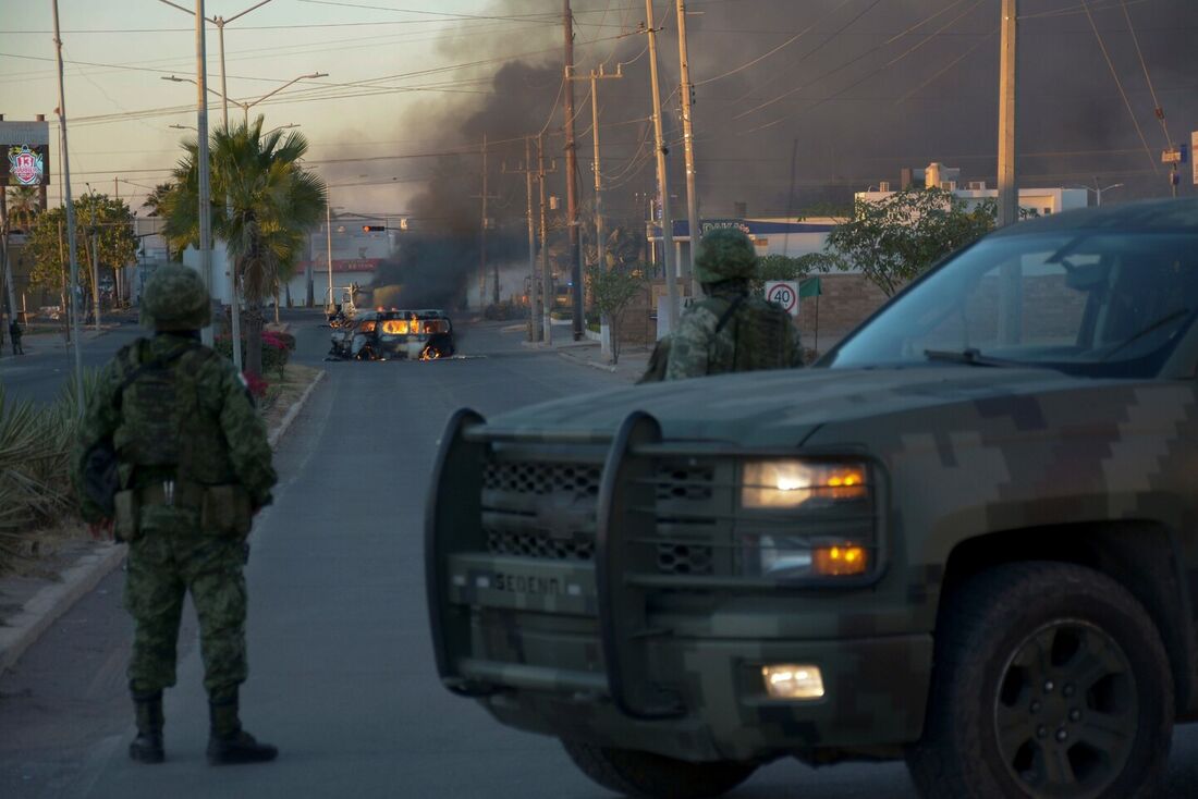 Soldados mexicanos montam guarda perto de veículos em chamas em uma rua durante uma operação para prender o filho de Joaquin "El Chapo" Guzman, Ovidio Guzman, em Culiacan, estado de Sinaloa, México, em 5 de janeiro de 2023