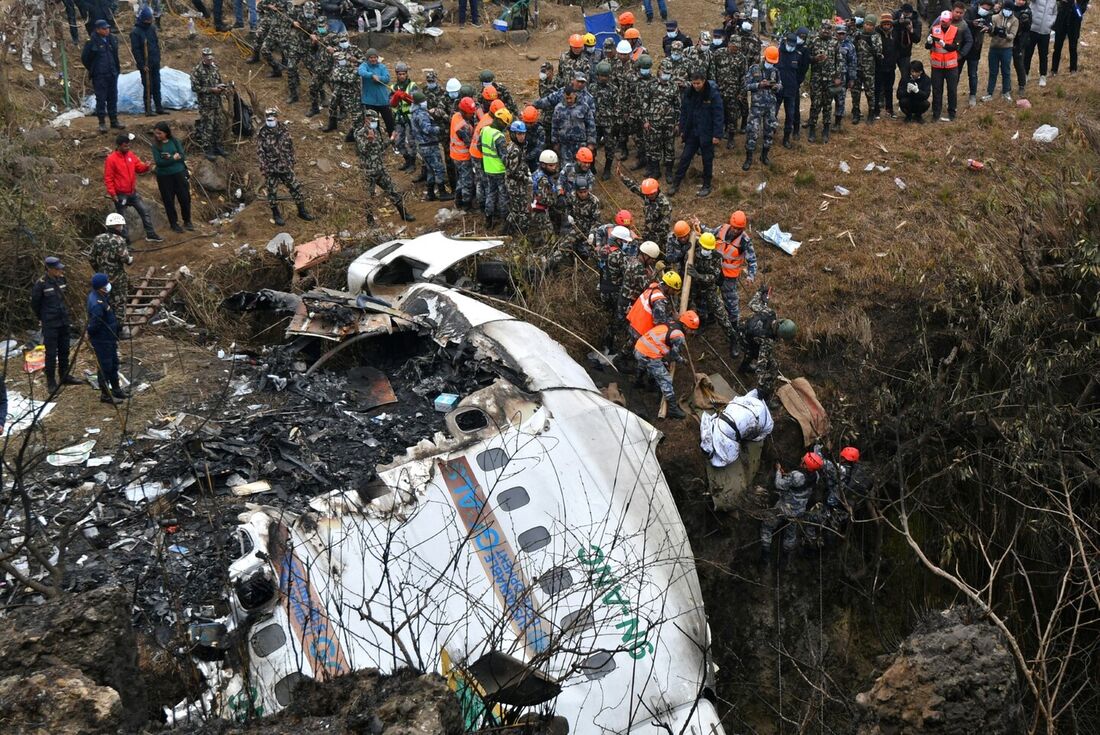 Equipes de resgate puxam o corpo de uma vítima que morreu em um acidente de avião da Yeti Airlines em Pokhara em 16 de janeiro de 2023