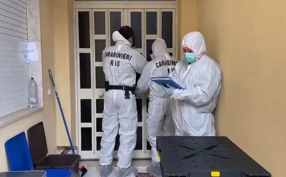 Oficiais forenses de Carabinieri tomando notas em frente à casa do chefe da máfia mais procurado da Itália, Matteo Messina Denaro, em Palermo, em sua ilha natal, a Sicília, após 30 anos foragido