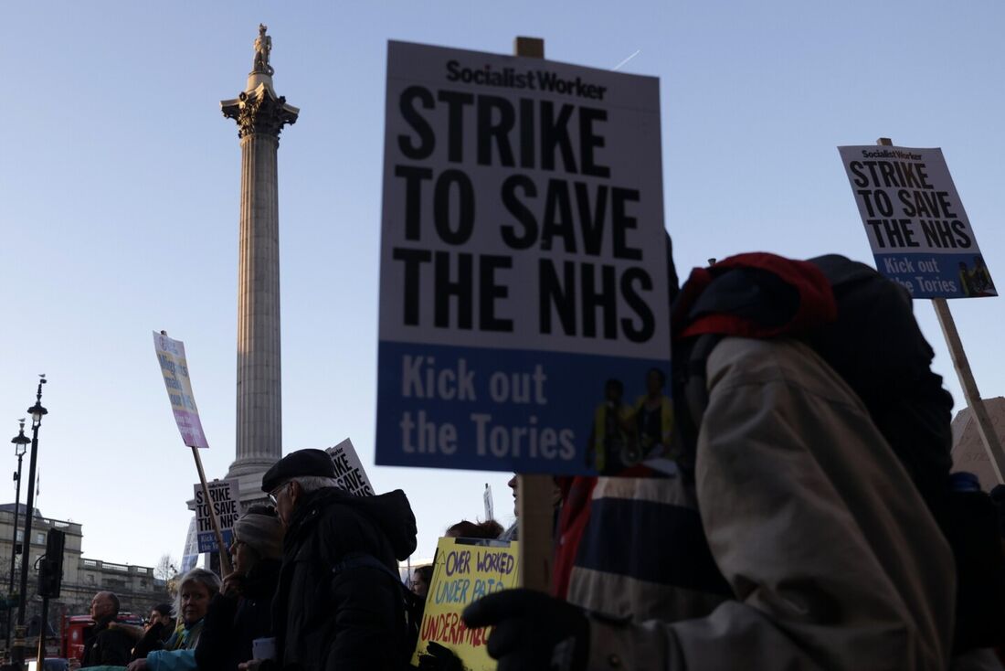 Cartazes durante uma marcha de protesto organizada pela Doctors Association UK, NHS Workers Say No! e NHS Staff Voices, em Londres, 18 de janeiro de 2023, em apoio às disputas salariais em andamento