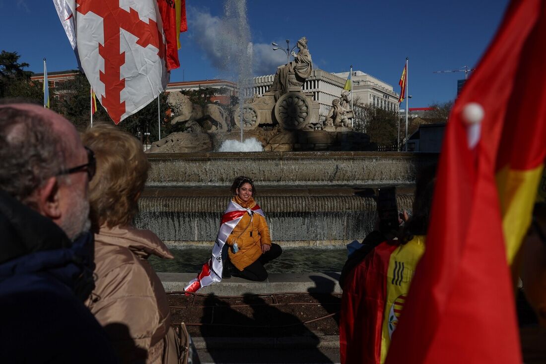 Um manifestante posa para fotos em frente à fonte Cibeles durante uma manifestação antigovernamental convocada por grupos de direita, na Plaza de Cibeles, em Madri, em 21 de janeiro de 2023