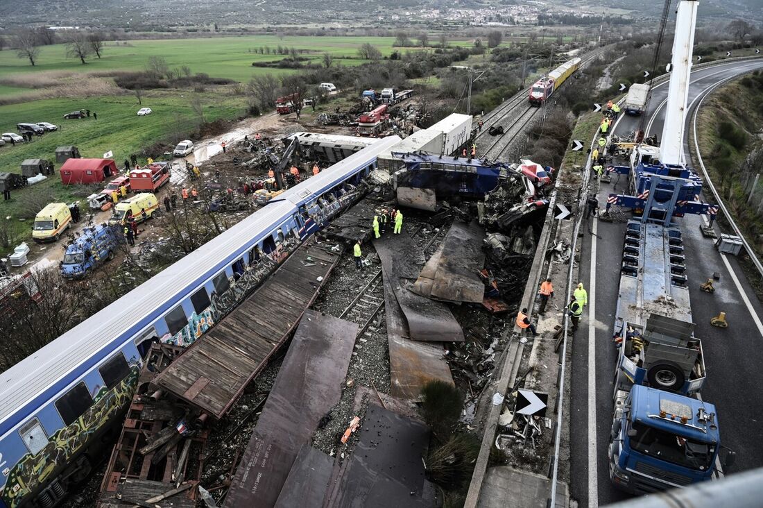 A polícia e equipes de emergência examinam os destroços de um vagão esmagado no segundo dia após um acidente de trem no Vale Tempi perto de Larissa, Grécia, 2 de março de 2023