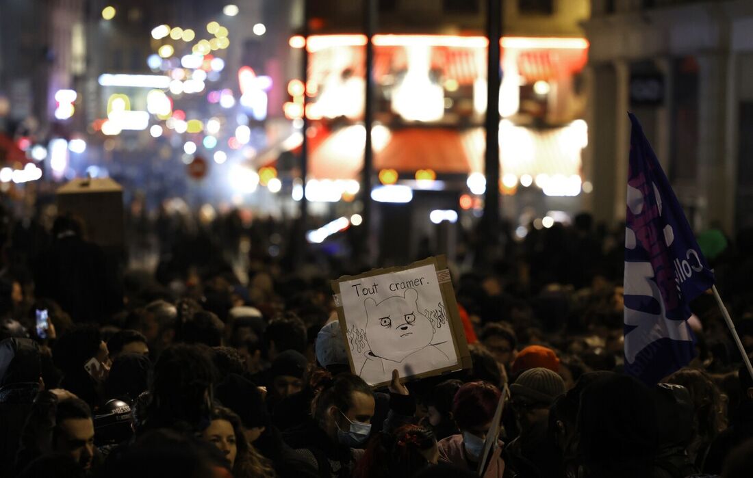 Um manifestante segura um cartaz com os dizeres "queimar tudo" na Place de la Republique durante uma manifestação, alguns dias depois de o governo ter aprovado uma reforma das pensões no parlamento sem votação, usando o artigo 49.3 da constituição