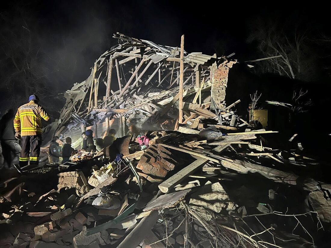 Socorristas trabalhando nos escombros de uma casa destruída por um ataque de míssil russo