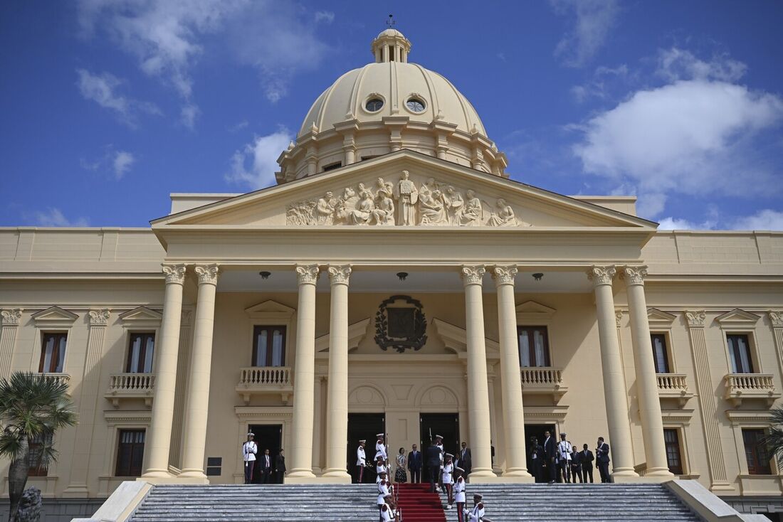 O presidente dominicano Luis Abinader (C) e a primeira-dama Raquel Arbaje aguardam a chegada do rei Felipe VI da Espanha no Palácio Nacional de Santo Domingo em 24 de março de 2023, no âmbito da XXVIII Cúpula Ibero-americana de Chefes de Estado e Governo