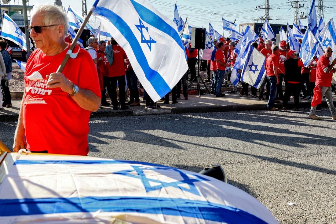 Veteranos militares israelenses agitam bandeiras nacionais durante uma manifestação contra o projeto de lei de reforma judicial do governo