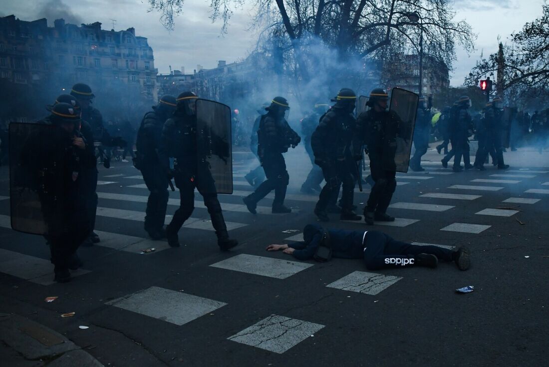 Um manifestante se deita no chão em frente à polícia de choque do CRS durante uma manifestação depois que o governo promoveu uma reforma das pensões no parlamento sem votação, usando o artigo 49.3 da constituição, em Paris, em 28 de março de 2023