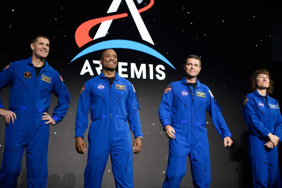 Os astronautas Jeremy Hansen, Victor Glover, Reid Wiseman e Christina Hammock Koch sobem ao palco após serem selecionados para a missão Artemis II, que se aventurará ao redor da Lua, durante coletiva de imprensa realizada pela NASA e CSA no aeroporto de E