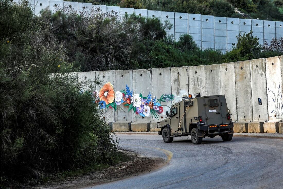 Um veículo militar israelense dirige ao longo da cerca de concreto da fronteira com o sul do Líbano, perto da vila de Shtula, no norte de Israel.