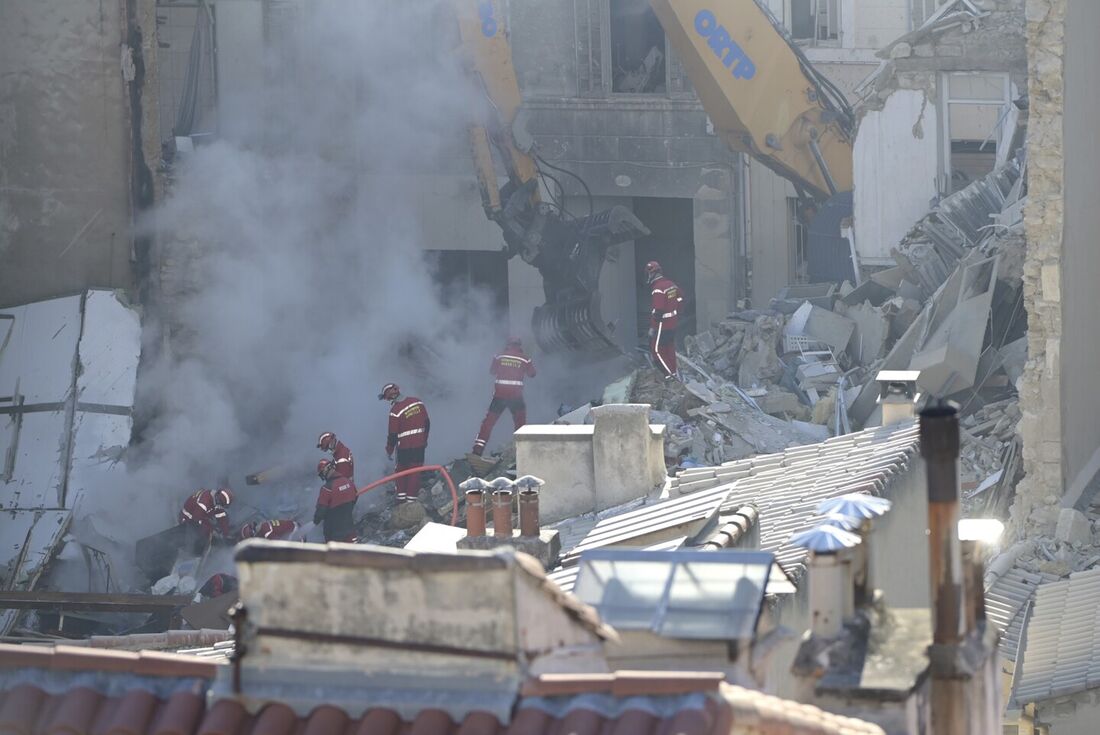 Bombeiros vasculham os escombros na 'rue Tivoli' depois que um prédio desabou na rua, em Marselha, sul da França.