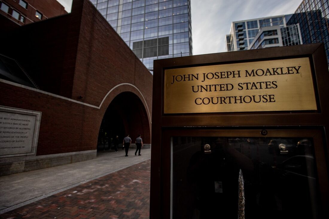 Seguranças caminham pela entrada do tribunal dos Estados Unidos John Joseph Moakley, em Boston, Massachusetts, em 14 de abril de 2023