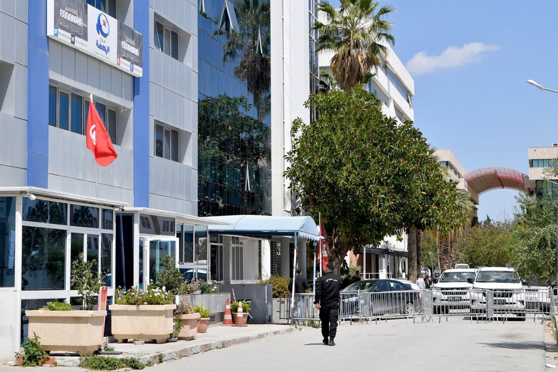  Um oficial de segurança da Tunísia caminha em frente à sede fechada do partido Ennahdha em Tunis.