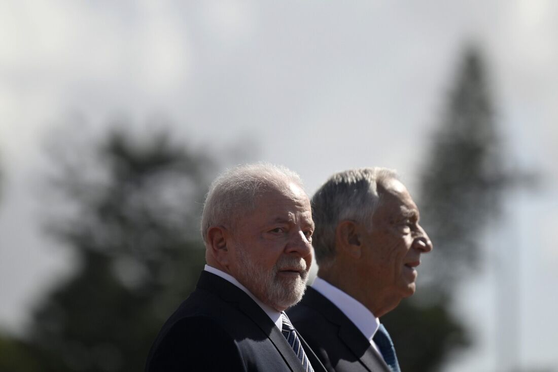 O presidente brasileiro Marcelo Rebelo de Sousa (R) e o presidente brasileiro Luiz Inácio Lula da Silva ouvem os hinos nacionais de seus países no Mosteiro dos Jerônimos em Lisboa em 22 de abril de