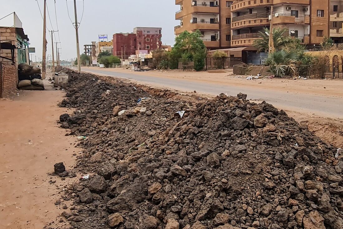 Uma barricada de sacos de areia é montada perto de uma trincheira ao longo de uma rua em Cartum enquanto a luta continua entre o exército do Sudão e as forças paramilitares