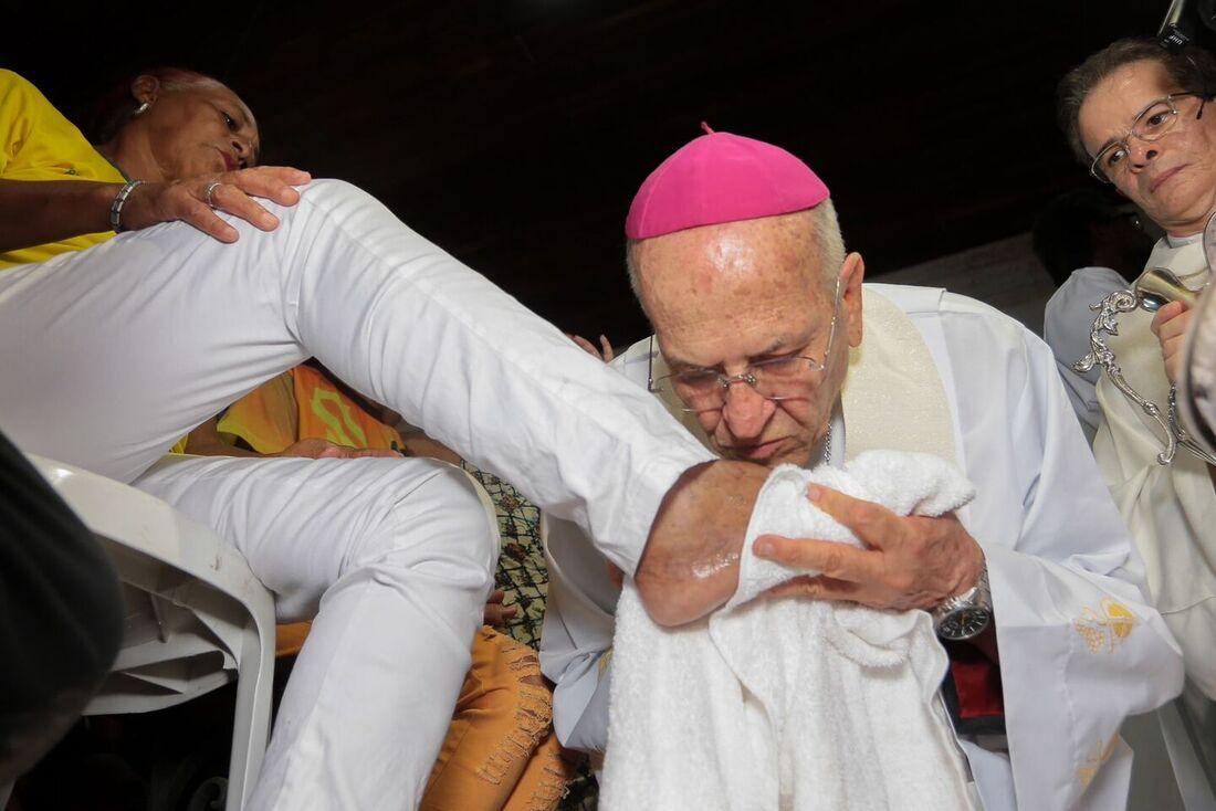 Dom Fernando Saburido beijando pé da moradora da comunidade do Pilar, Vera Lúcia do Nascimento, durante celebração