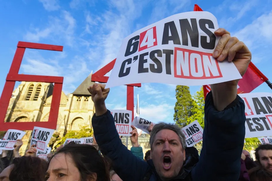 Manifestante segura cartaz escrito '64 anos não', em referência à nova idade mínima para aposentadoria que será adotada após a reforma, em Le Mans, na França 