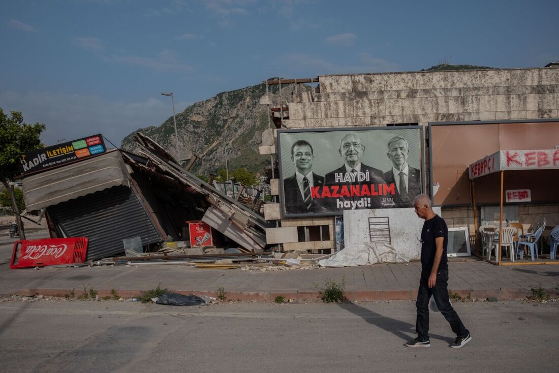 Um homem passa por um cartaz de campanha eleitoral do Partido Republicano do Povo (CHP) em Hatay, cidade que sofreu mais danos nos terremotos ocorridos no sul da Turquia, em 12 de maio de 2023