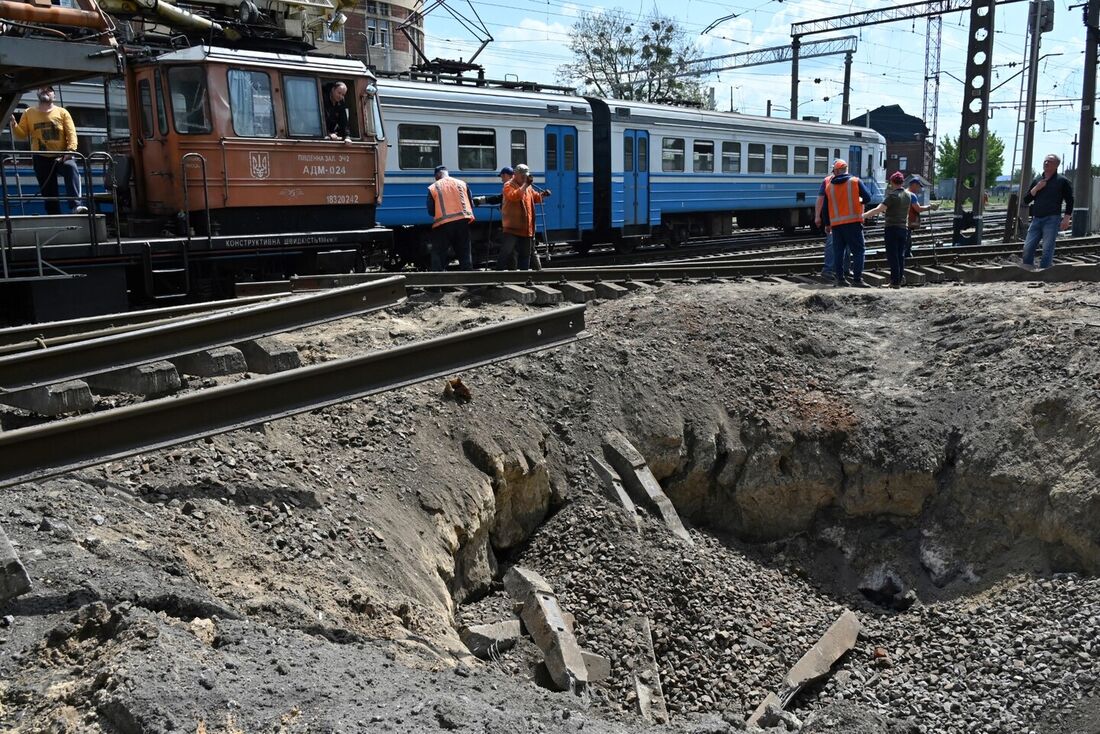 Homens trabalham, nesse domingo, em cratera após explosão causada perto de Kharkiv