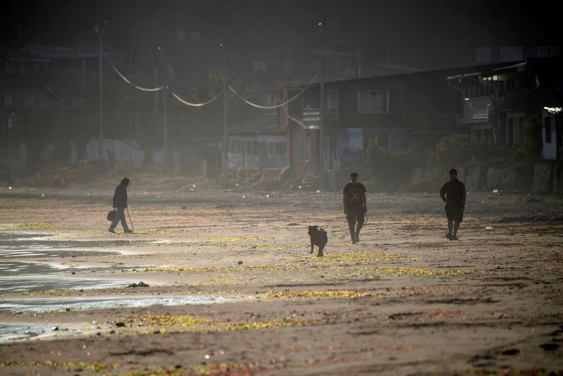 Pessoas caminham na praia de Ventana, perto da usina termoelétrica AES Gener em Puchuncavi, região de Valparaíso, Chile, 9 de junho de 2022