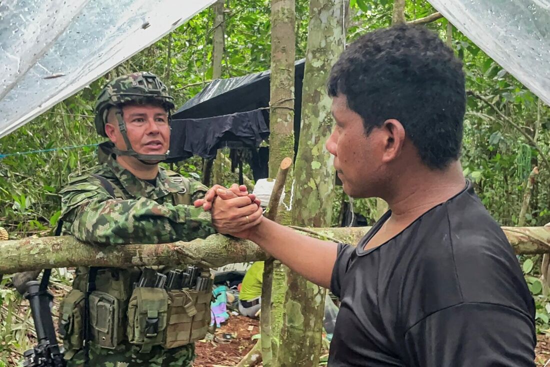 Exército da Colômbia mostra Manuel Ranoque (R), pai das quatro crianças desaparecidas, apertando a mão de um membro do Exército colombiano que busca as crianças desaparecidas na floresta amazônica colombiana no município de Solano, departamento de Caquetá