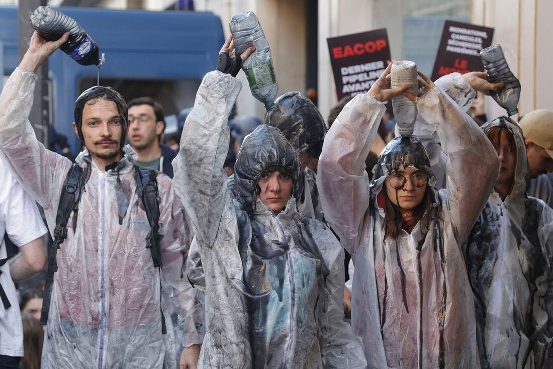 Manifestantes climáticos derramam óleo sobre eles enquanto brigas entre policiais e manifestantes estouraram com o uso de gás lacrimogêneo durante uma manifestação nos arredores do local de Paris para a Reunião Geral Anual da TotalEnergies em Paris.