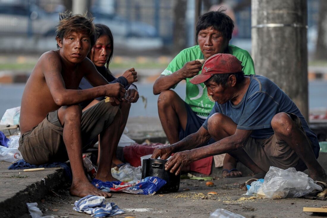 Indígenas Yanomami comem comida doada na rua em Boa Vista, Roraima.