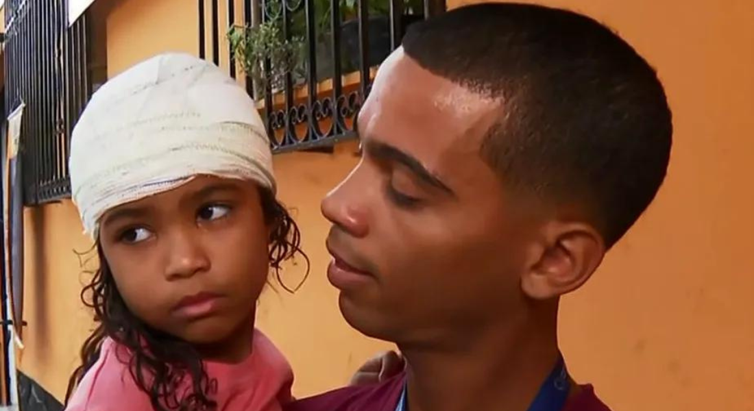 Menina Valentina com o tio ao deixar hospital para onde foi levada após desabamento de casa no Morro da Cotia