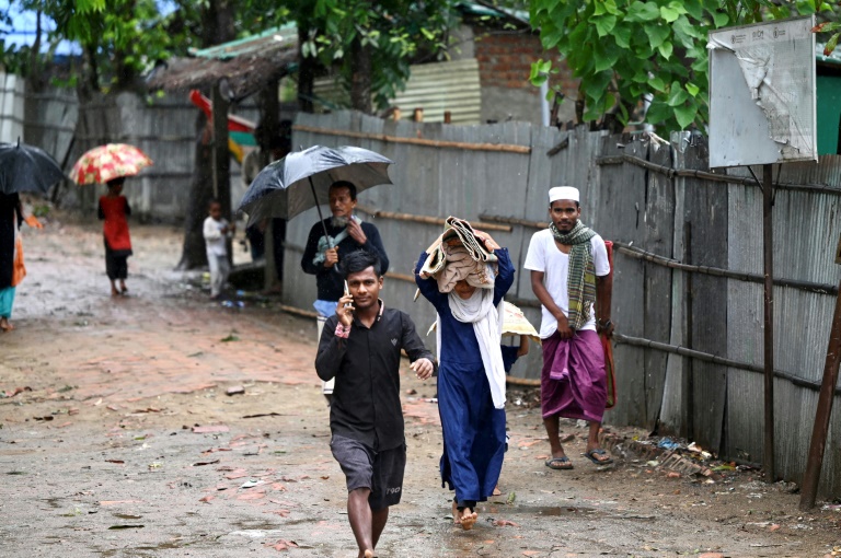 Moradores levam seus pertences para um abrigo na ilha de Shahpori, nos arredores de Teknaf, em 14 de maio de 2023, antes da chegada do ciclone Mocha