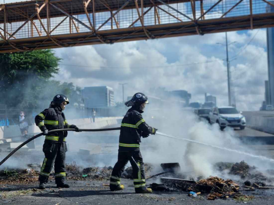 Bombeiros apagando o fogo do protesto na Agamenon Magalhães, próximo ao Viaduto Capitão Temudo